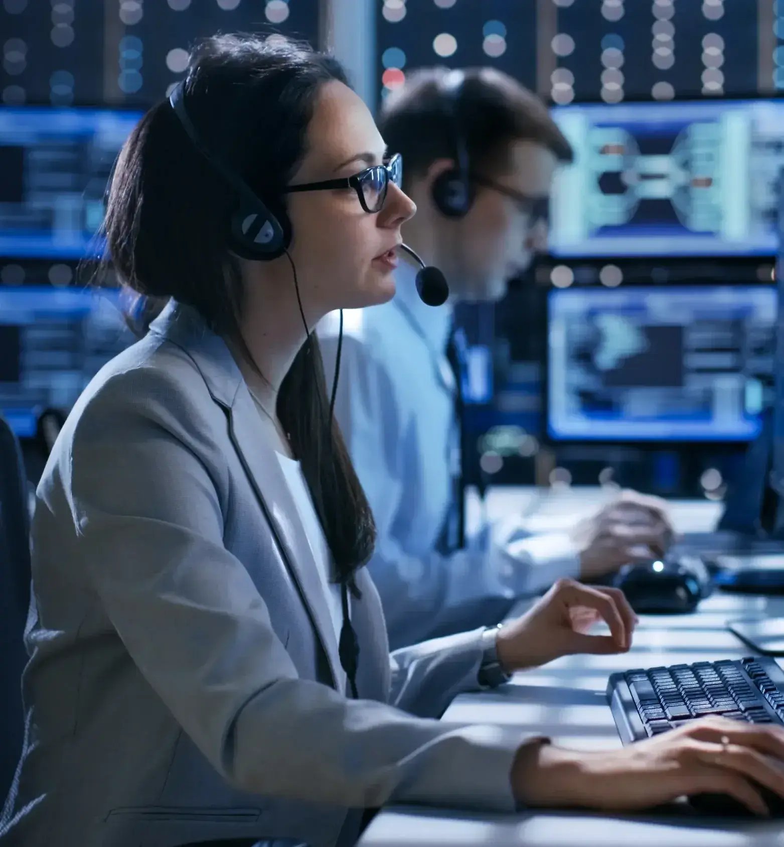 Data support operator with headset helping a customer, with data banks behind-1