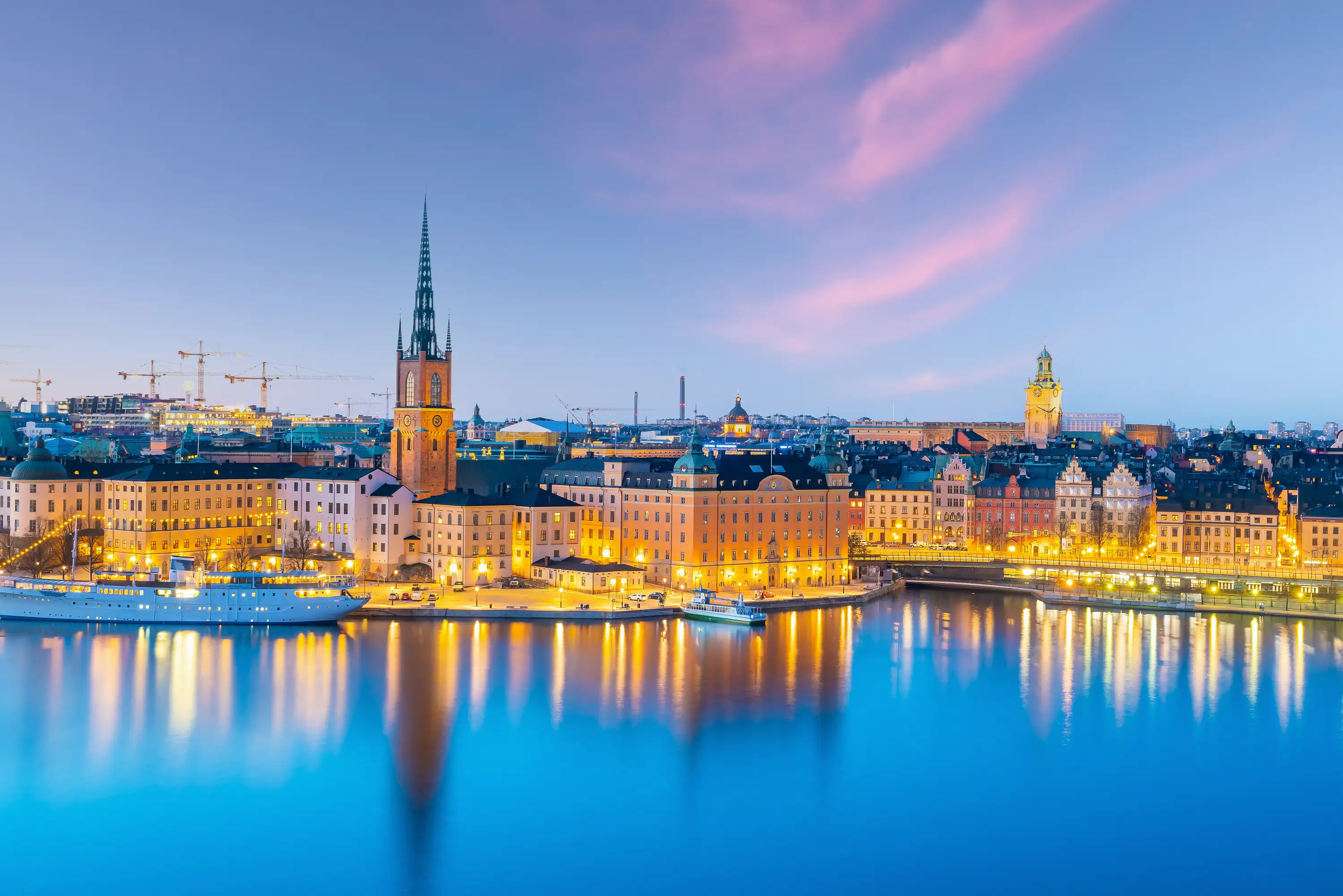 Stockholm, skyline on a still river with cranes on the horizon